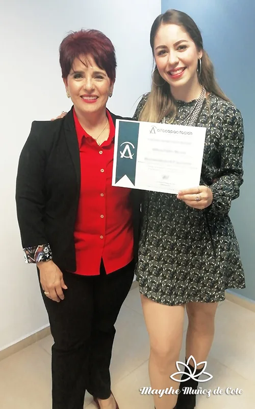 Maythe Muñoz de Cote, entregando su reconocimiento a una alumna contenta